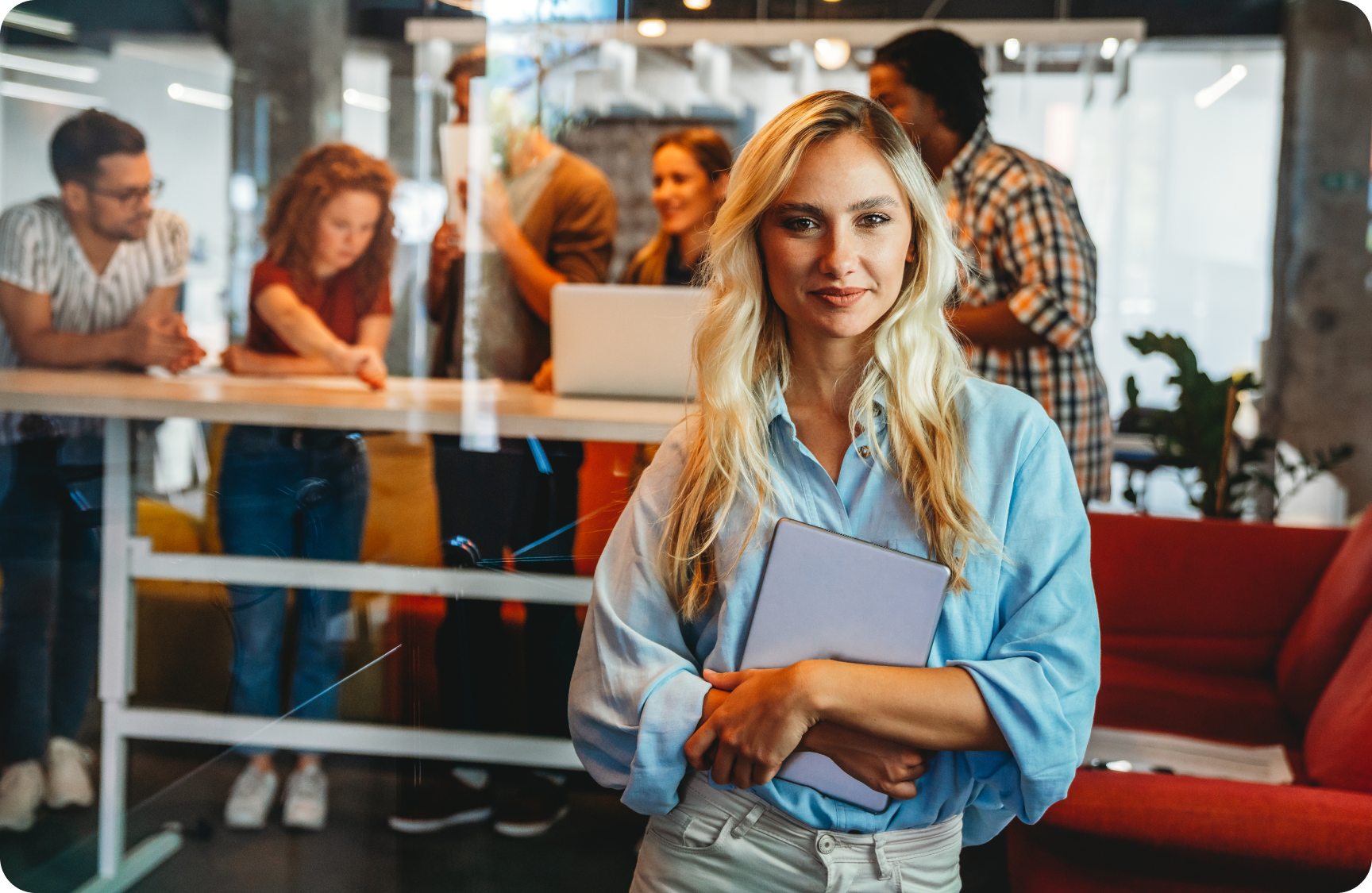 person in office with colleague behind working on laptop