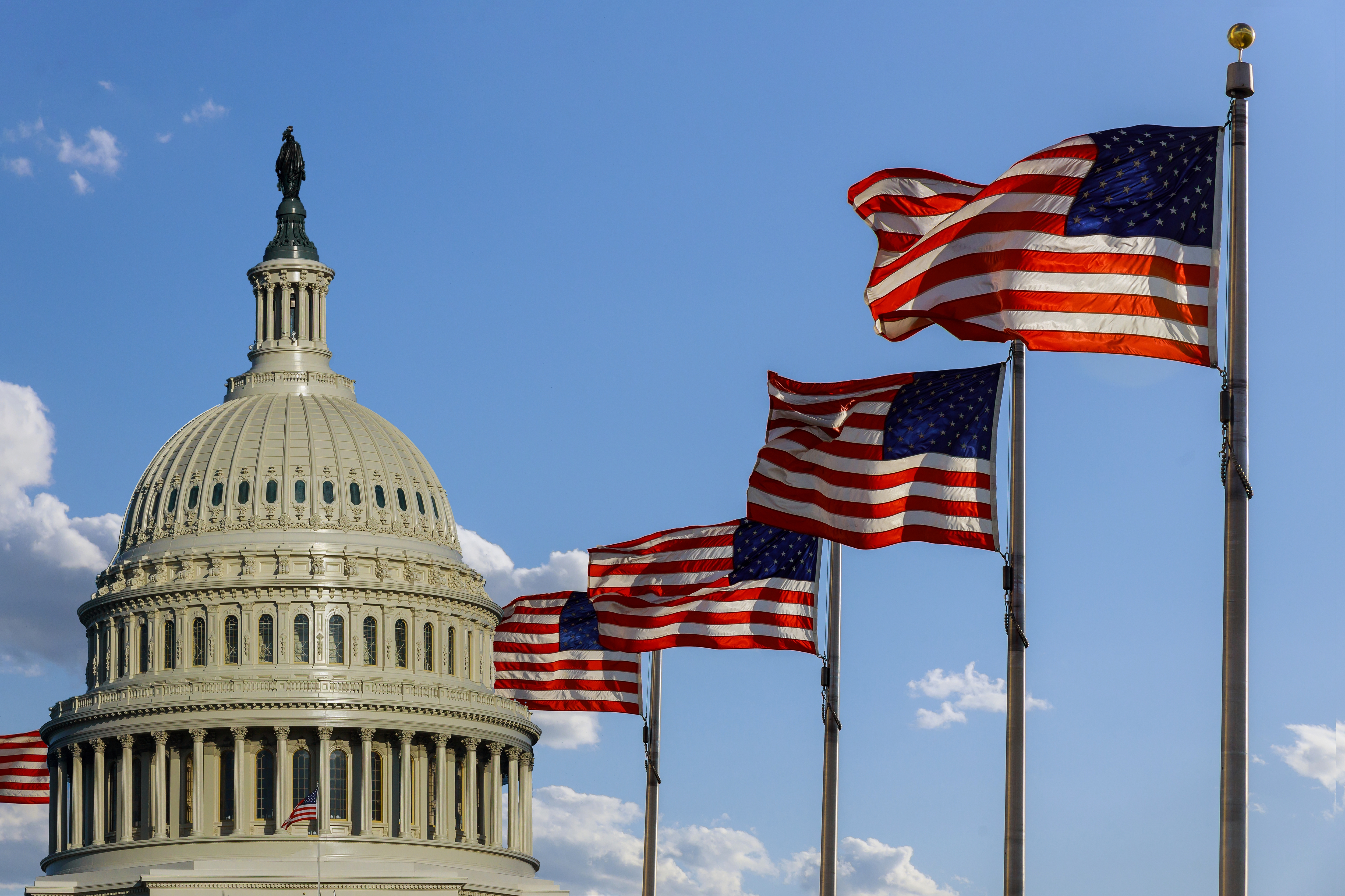 a photo of the Capitol building and four flags of the United States