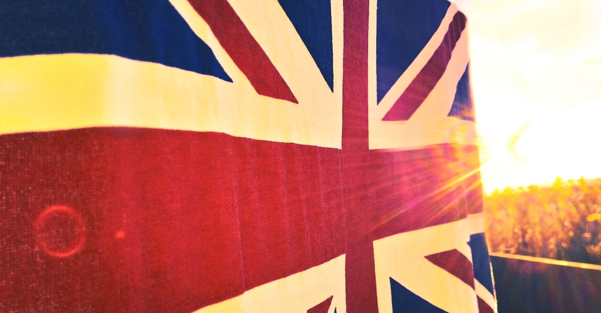 The flag of Great Britain flying against sunset and lens flare.