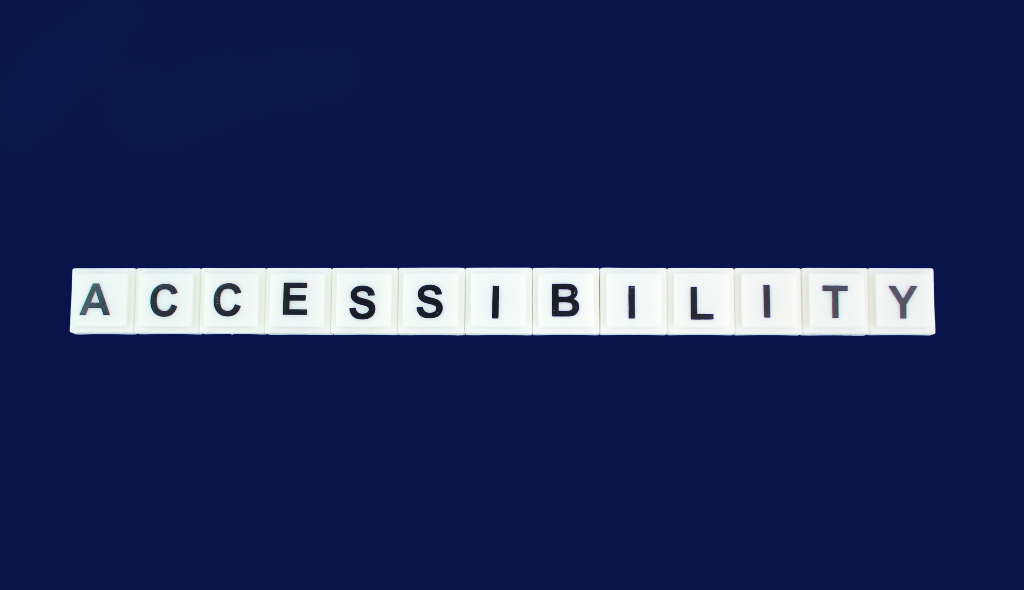scrabble tiles spelling the word accessibility on a blue background